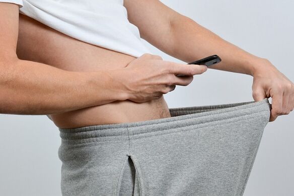 A man looks down at an enlarged penis